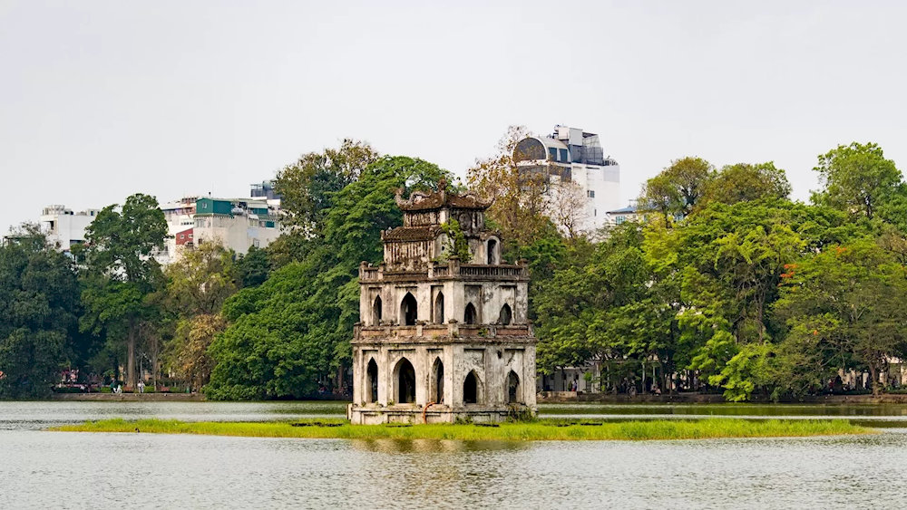 Morning in Hoan Kiem Lake awakens with golden reflections on tranquil water